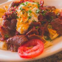 Iskender Plate · Beef and lamb gyro mixed with tomato sauce, layered with soft pita bread pieces, and covered...