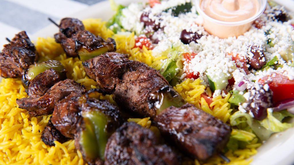 Lamb Kebab Plate · Two lamb kebab skewers served with a bed of basmati rice and Greek salad.
