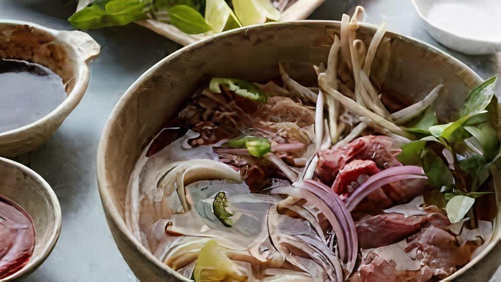 Beef Pho Soup · 20 hours rich broth, wide rice pho noodle, rare steak, brisket, meatballs, scallions, red onion, cilantro, bean sprout, limes, basil