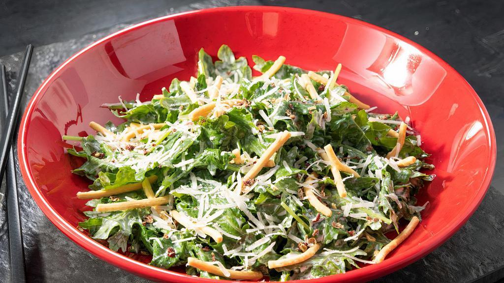 Chinese Kale Salad · Tender baby kale and chow mein noodles tossed in creamy yuzu dressing. Garnished with grana cheese and fresh cracked Szechuan pepper.