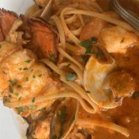 Cioppino · Fresh salmon, shrimp, clams, mussels and scallops in a fresh herb spicy seafood broth over l...