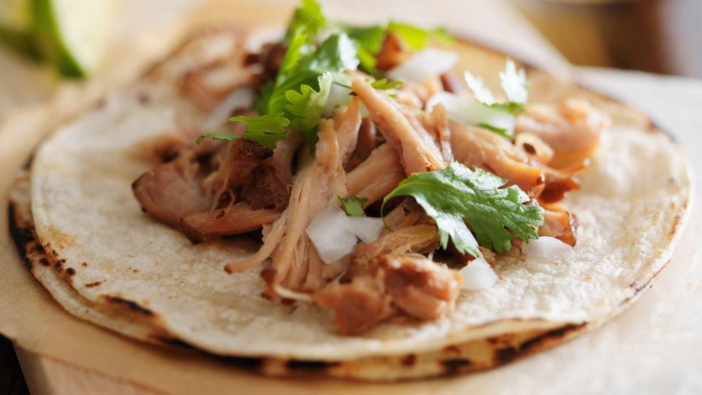 Carnitas Street Taco · Flavorful carnitas (pork), lettuce, and creamy cheese sitting on a fresh made tortilla.