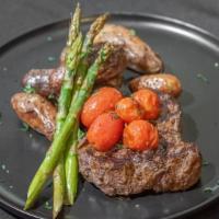 Ribeye Steak · 10 oz ribeye steak, served with roasted fingerlings, grilled asparagus and blistered tomatoes.