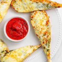 Garlic Bread · House-made flat bread with garlic butter spread. Served with marinara cup.