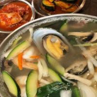 Kal Guksu · Knife cut wheat flour noodle soup with seafood and vegetables served in a large bowl with br...