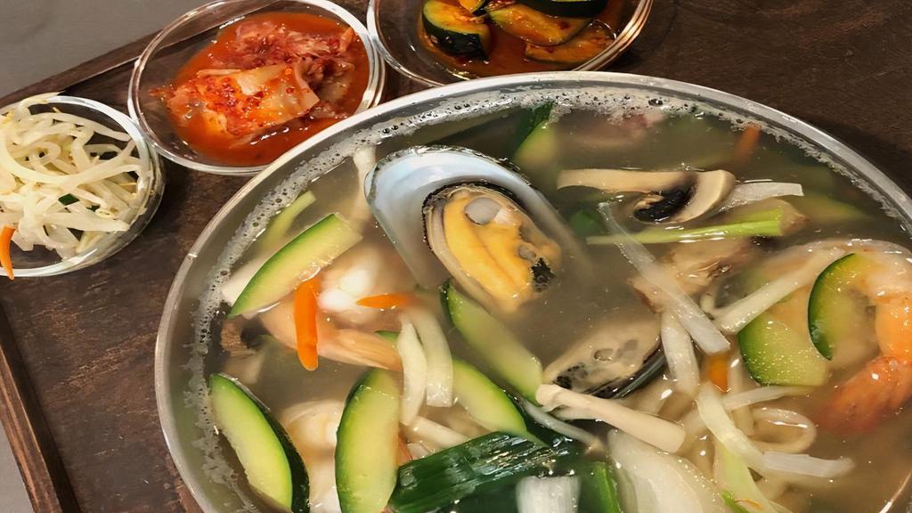 Kal Guksu · Knife cut wheat flour noodle soup with seafood and vegetables served in a large bowl with broth.