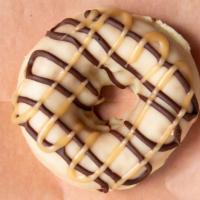 Banana Caramel (Vegan) · Vegan Cake donut in our Banana glaze and topped with a caramel and chocolate drizzle!