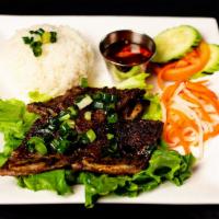 Cơm Bò Nướng* · Marinated short ribs served with broken rice, carrot and daikon, and sliced cucumber and tom...