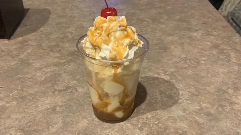 Vanilla Ice Cream Sundae With Caramel Syrup · Vanilla ice cream served with caramel syrup, cool whip and topped with a cherry, peanuts and whip cream.