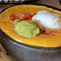 Aztec Dip · Ground beef, refried, and black beans, tomatoes, guacamole, sour cream, chile con queso.