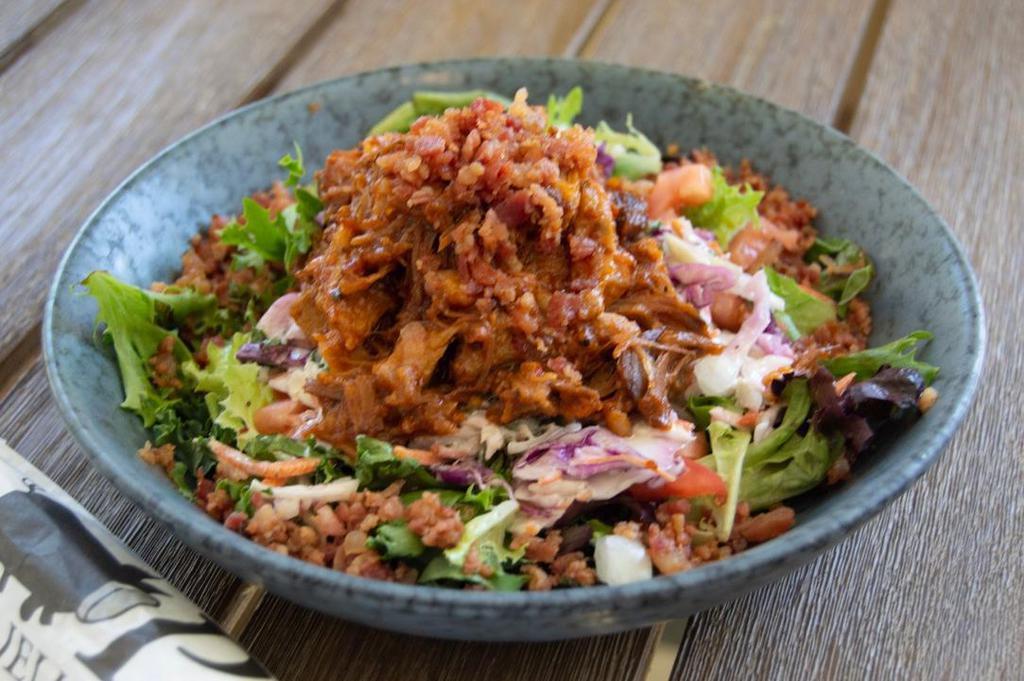 Bbq Pulled Pork Salad · Local pulled pork, homemade BBQ sauce, creamy slaw dressing, green leaf lettuce, shredded kale, slaw, diced tomato and onions, and chopped local bacon.