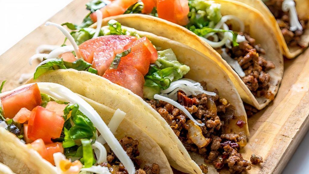 Taco Plate · Three tacos with corn tortillas layered with mozzarella cheese and your choice of veggies or meat (asada, chicken, or ground beef) and topped with pinto beans, tomatoes, onions, salsa and sour cream, and a bit of cotija cheese.