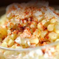 Esquite · Corn grains served hot on a cup and topped with mayo, sour cream, cotija cheese, and chili p...