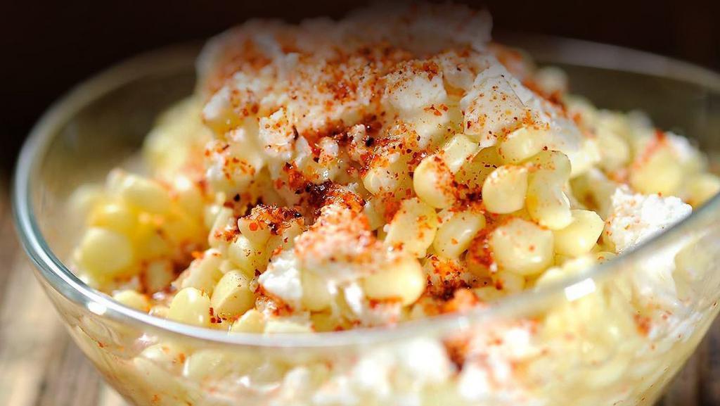 Esquite · Corn grains served hot on a cup and topped with mayo, sour cream, cotija cheese, and chili powder.
