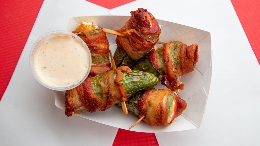 Jalapeño Poppers · Large jalapenos stuffed with cream cheese, and wrapped in bacon served with our own habanero ranch sauce.