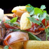 Lomo Saltado · Filet mignon sauteed with onions, tomatoes, soy sauce, vinegar, and Peruvian spices, served ...