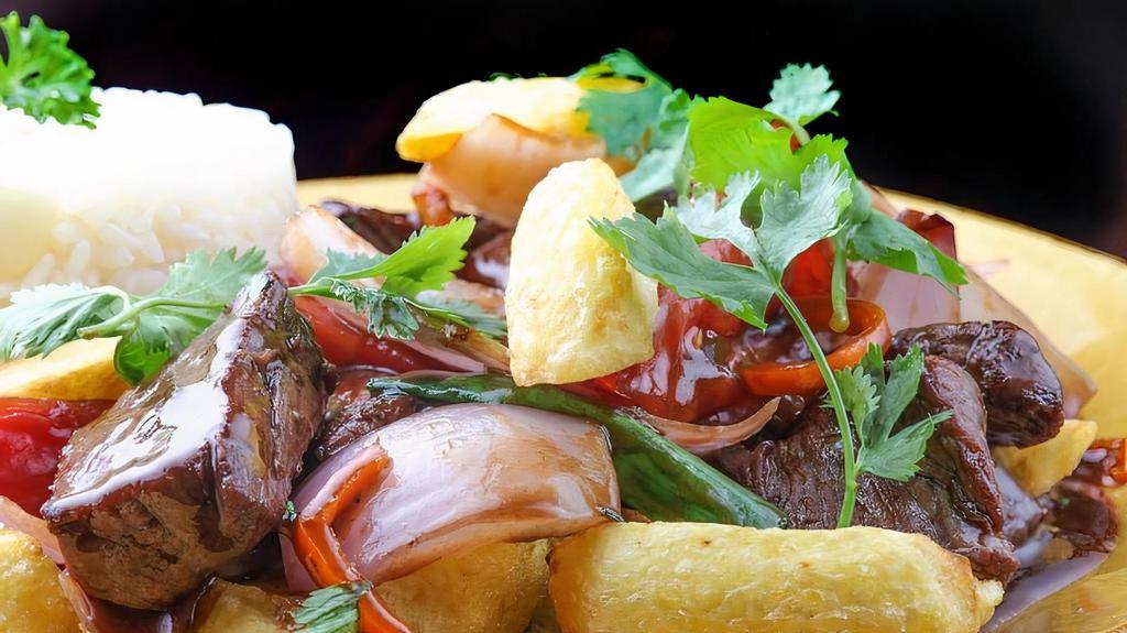 Lomo Saltado · Filet mignon sauteed with onions, tomatoes, soy sauce, vinegar, and Peruvian spices, served with fries and steam rice.