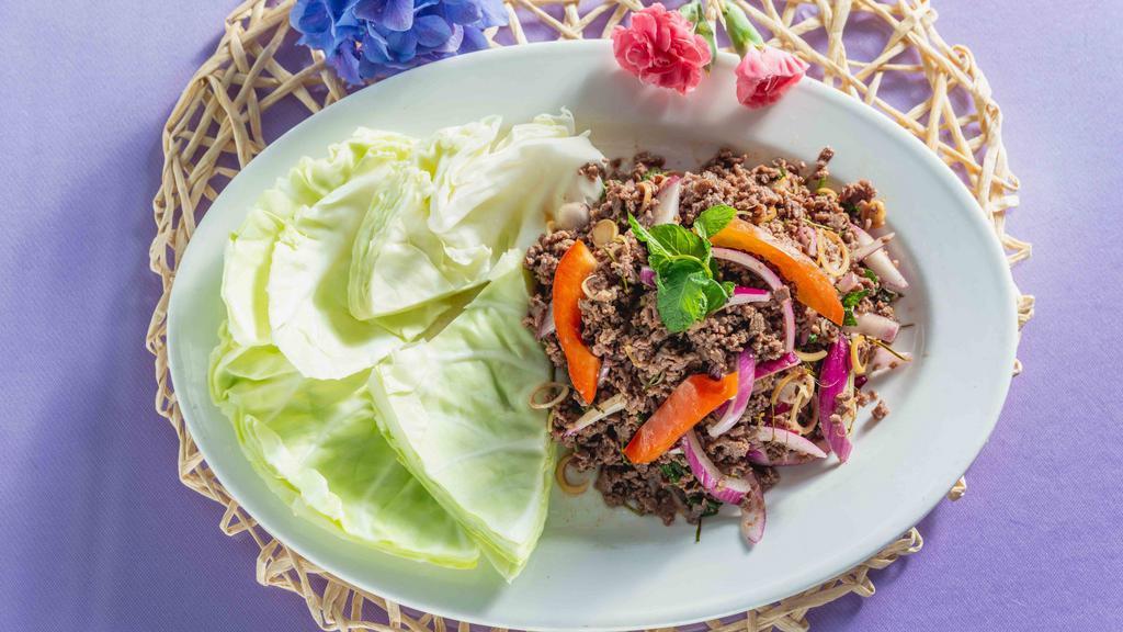 S-10.) Larb Beef Salad / Goi Bo Kieu Thai · Red onions, green onions, cilantro, chili, lime juice, lime leaves and crushed toasted rice with ground beef, wrapped in fresh cabbage, which are served on the side.