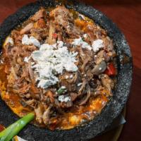 Carnitas Molcajete · Our savory carnitas roasted in chilies and oranges then simmered in our famous molcajete sau...