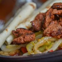 Grilled Steak Fajitas · An 8 oz portion of grilled top quality beef, marinated in Mexican spices and served over faj...
