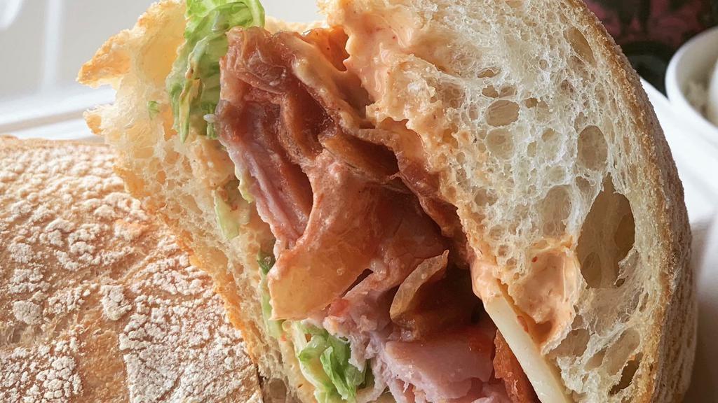 Scorched Pig Sandwich · Ciabatta, Scorch Sauce, Ham, Caramelized Onions, Tomato Jam, Bacon, Provolone, & Lettuce