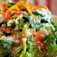 Caesar · Romaine tossed with garlicky, anchovy dressing, Fatima cheese and topped with tortilla strip...