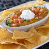 Queso Dip · A mild creamy blend of pepper Jack & cheddar cheese, diced jalapeños & taco meat. Topped wit...