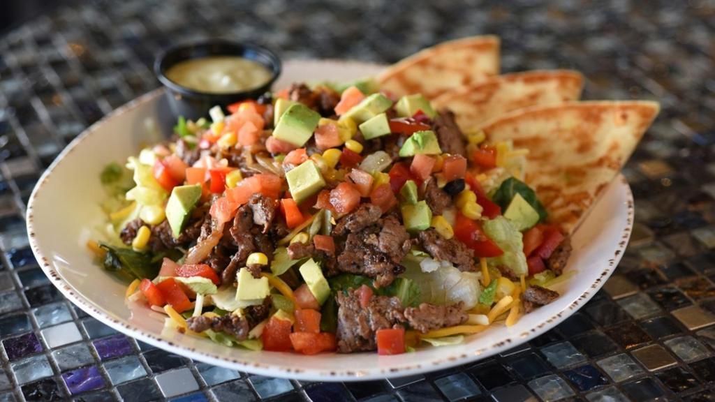 Fajita Steak Salad · Tender steak with mixed greens, cheddar & pepper Jack cheese, caramelized onions, Baja veggies, red peppers, tomatoes, cheese and avocado. Served with grilled pita bread and Avocado Ranch.