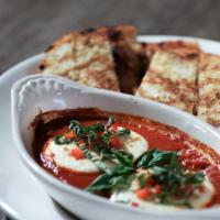 Caprino · Goat cheese in a spicy roasted red pepper tomato sauce. Served with grilled garlic toast.