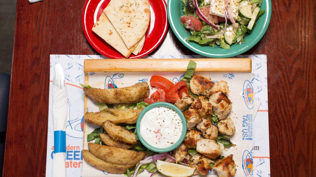Chicken Souvlaki Plate · Two skewers of marinated chicken breast served with rice, 1/2 pita bread, and salad.