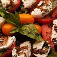 Caprese · Fresh mozzarella, roma tomato slices and basil layered over mixed greens, drizzled with bals...