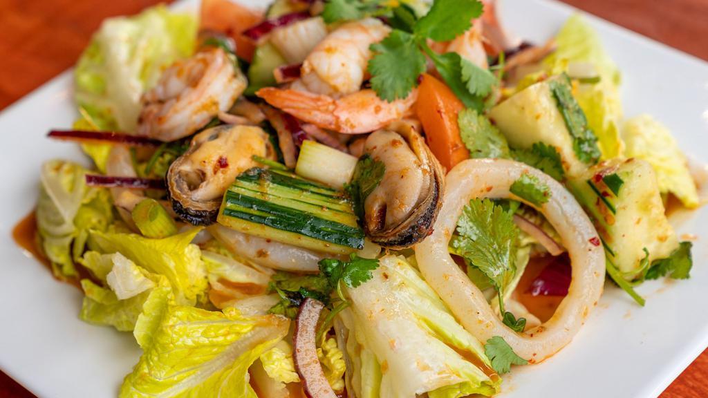 Seafood Salad · Grilled jumbo prawns, scallops, calamari, mussels, tomato, lemongrass, spring mix, cucumber, onion, cilantro, kaffir leaves, mint, sweet chili paste with spicy lime dressing.