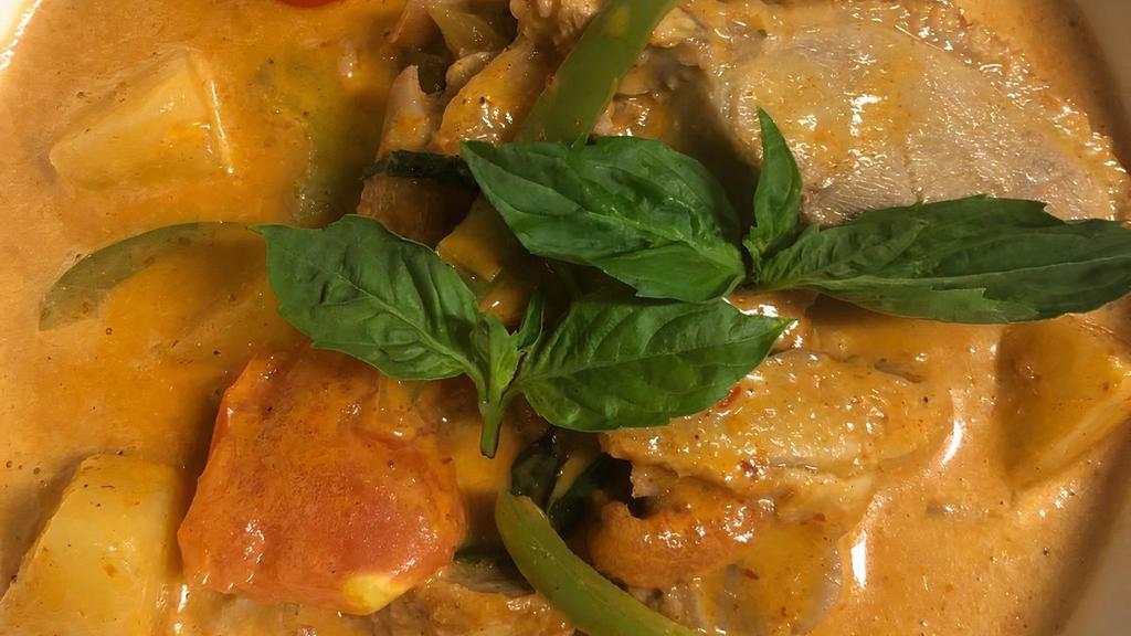 Duck Curry · Roasted duck with bell peppers tomatoes, pineapple, sweet basil leaves in red curry.