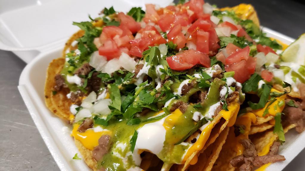 Mexican Nacho Supreme · Chips, shredded cheese, nacho cheese, choice of meat, cilantro, onions, tomatoes, jalapeños, salsa, sour cream.