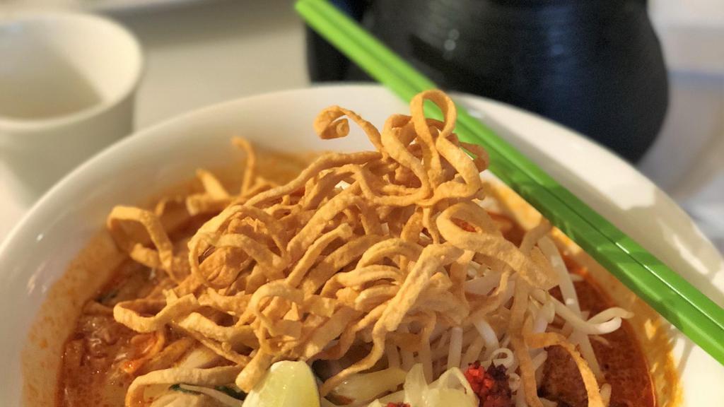 Khao Soi:* · Famous Northern-style curry with egg noodles, chicken, shallots, Thai pickled cabbage, and bean sprouts, topped with crispy noodles, green onion, and cilantro.