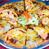 Machaca Pizza · Crispy flour tortilla with melted cheese,  New Mexican red chile, tomatoes and machaca beef....