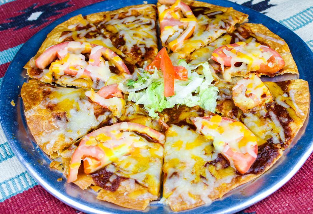 Machaca Pizza · Crispy flour tortilla with melted cheese,  New Mexican red chile, tomatoes and machaca beef. Spicy.