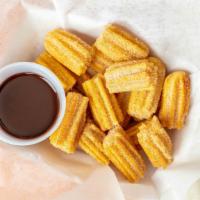 Churro Bites  · Churro Bites 10 Pieces tossed in Cinnamon & Sugar with a choice of chocolate or Nutella dipp...