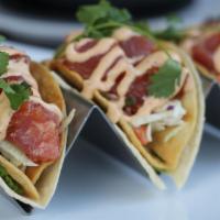 Poke Taco · Three soft and hard shell tacos with six ounces of poke, edamame hummus, slaw, spicy aioli, ...
