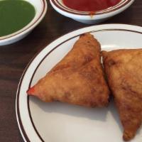 Lamb Somosa  · Crisp patties stuffed with ground lamb, green peas and spices wrapped in a home made flour p...