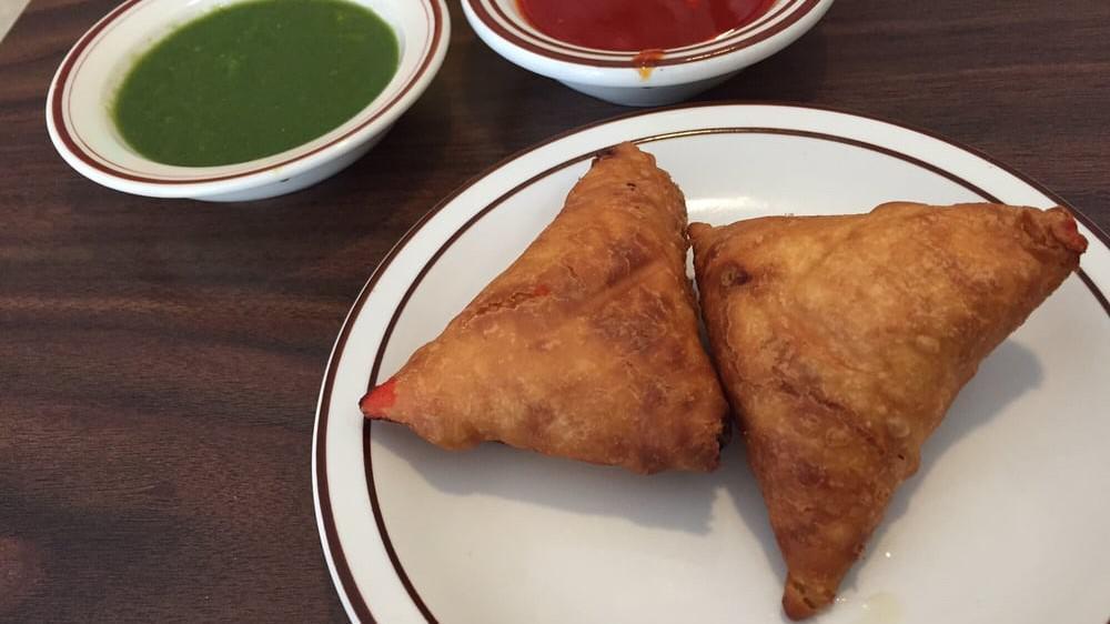 Lamb Somosa  · Crisp patties stuffed with ground lamb, green peas and spices wrapped in a home made flour pastry dough and deep fried.
