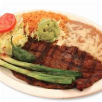Carne Asada · Broiled skirt steak. Served with rice, beans, salad, guacamole, green online, jalapeno peppe...