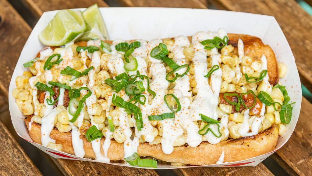 Elote Dog · Buttery grilled street corn, mayo, cayenne, green onion, and lime wedge.