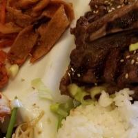 Kalbi · Grilled beef short ribs marinated in sweet soy sauce. Served with steamed rice and side dish...
