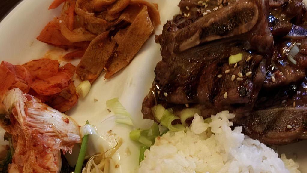 Kalbi · Grilled beef short ribs marinated in sweet soy sauce. Served with steamed rice and side dishes.