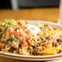 Super Nachos · Tortilla chips topped with beans, ground beef, melted cheese, sour cream, and guacamole.