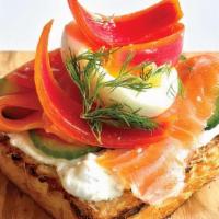 Greek God · smoked salmon, lemon ricotta, cucumber, pickled onion, tomato, dill, with a jammy egg on eng...
