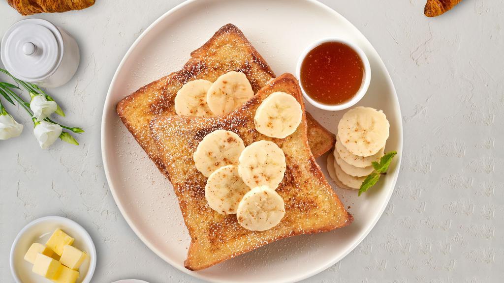 Banana Peanut Butter French Toast · Fresh bread battered in egg, milk, and cinnamon cooked until spongy and golden brown. Topped with powdered sugar, banana, nutella, maple syrup, butter, and served maple syrup. Four slices.