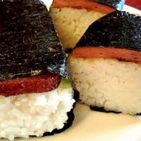 Spam Musubi · Slice of grilled Spam sandwiched top of a block of rice, wrapped together with seaweed.