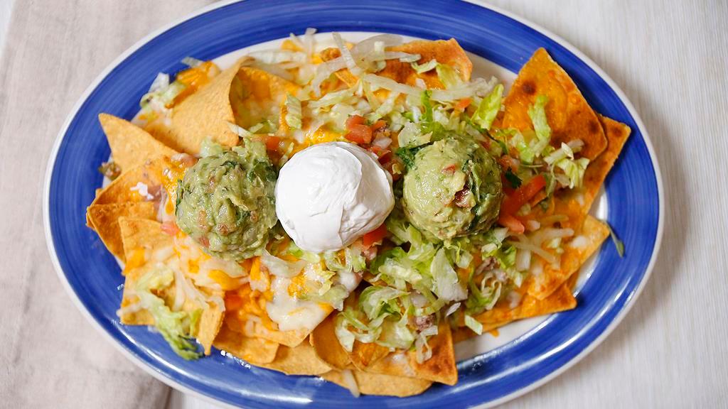 Nachos · Homemade tortilla chips topped with your choice of meat ( ground beef or chicken) beans, melted cheese, covered with lettuce, pico de gallo, sour cream, and guacamole.
CHIPS AND SALSA